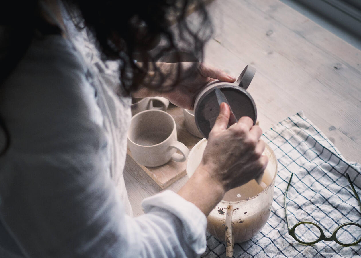 Ceramic artist working with clay in her pottery studio