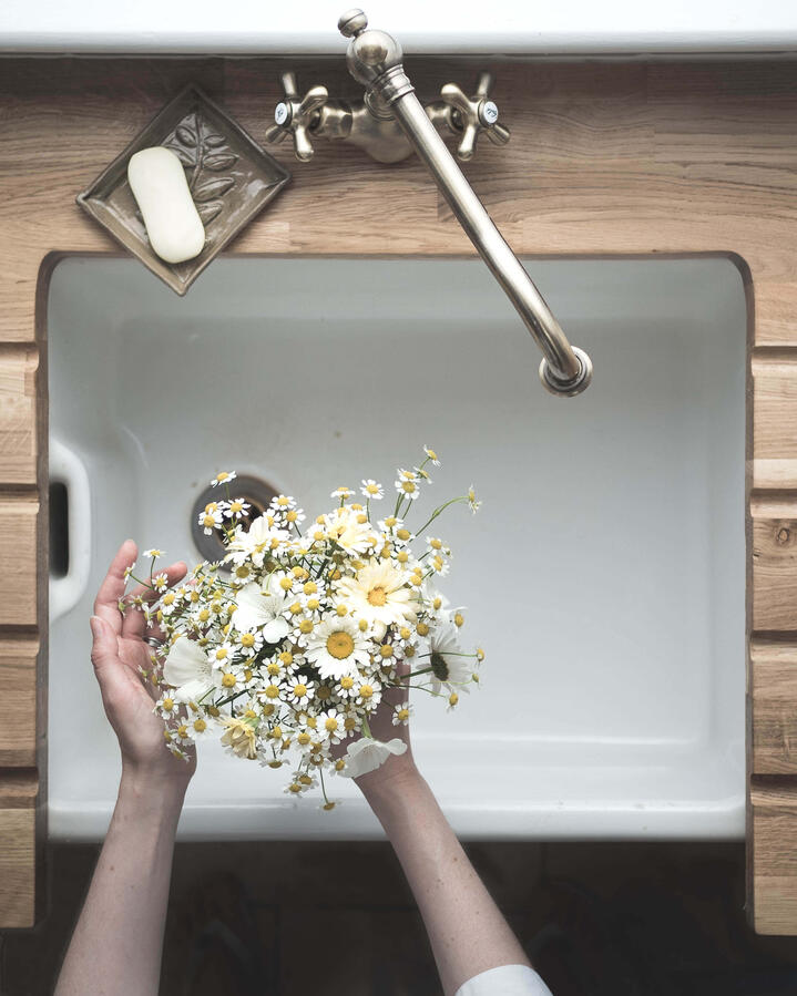 Seasonal flowers arranged and held over a rustic belfast sink
